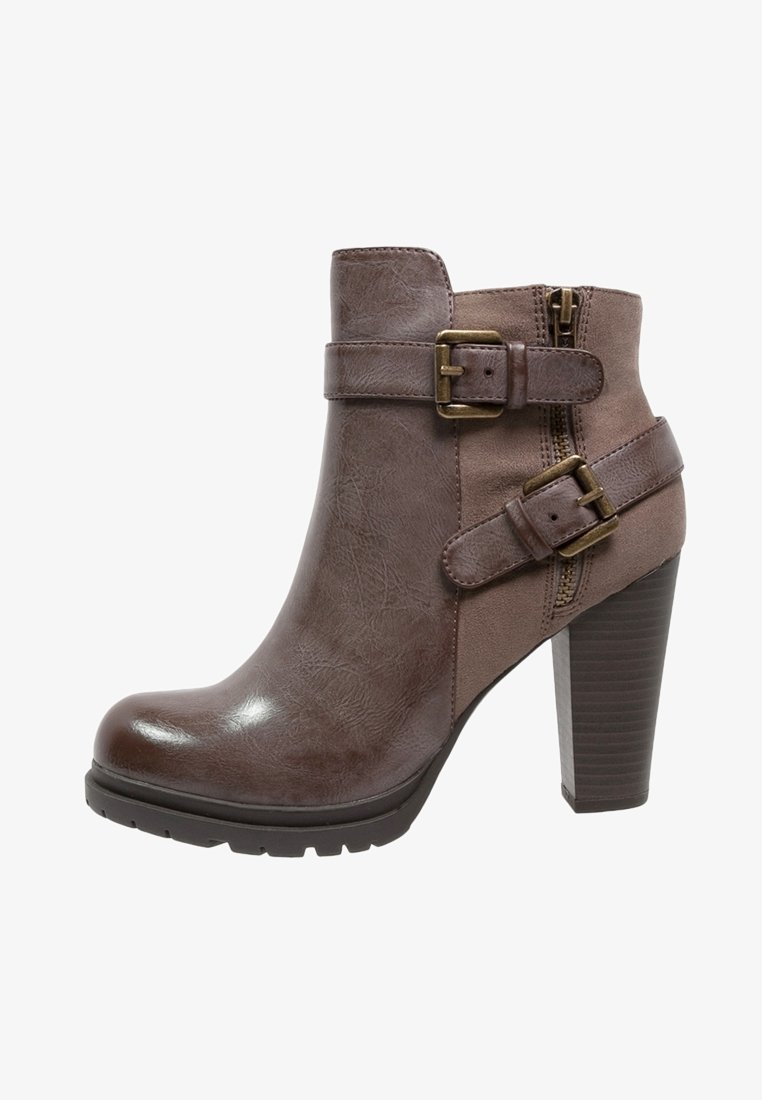 Bottine en cuir marron avec deux boucles en laiton réglables, fermeture éclair latérale, talon haut épais et semelle robuste.