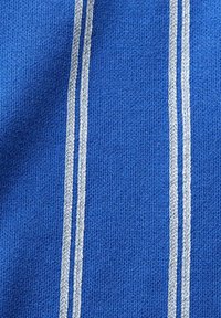 Tela de punto azul con dos franjas verticales plateadas. La textura es suave y uniforme, con una apariencia de punto cerrado.