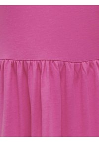 Abito rosa con una texture morbida e liscia, dotato di un volant arricciato all'orlo che crea una silhouette fluida.