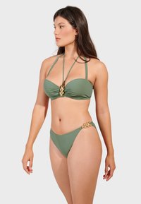 Zestaw bikini w kolorze oliwkowym z wyściełanym topem bandeau, regulowanymi ramiączkami i złotymi akcentami w kształcie liści na majtkach. Gładka tekstura, minimalistyczny design.
