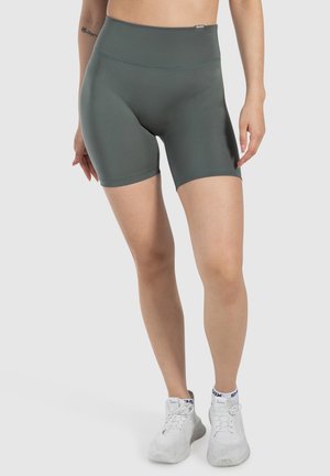 Hochgeschnittene grüne Sportshorts aus dehnbarem Material. Sie verfügen über eine glatte Textur und einen elastischen Bund, mit sichtbaren Nähdetails.