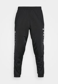 Pantalons de sport noirs en matériau lisse et léger. Ils présentent une taille élastique, des jambes fuselées et des accents de logo blancs sur les côtés.