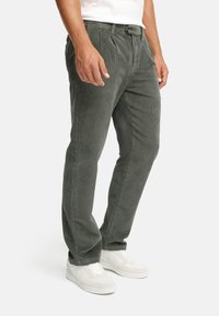 Gray corduroy trousers with a straight-leg design, featuring a textured surface, belt loops, and side pockets, paired with white sneakers.