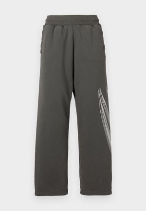 Dunkelgraue Jogginghose mit lockerer Passform, seitlichen Taschen und einem weißen Blumenmotiv auf dem linken Bein. Elastischer Bund.