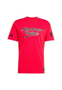 Camiseta de algodón roja con el texto "Manchester United" en negro, con el logo negro de Adidas en una manga y el logo del león en la otra.