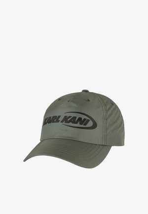Olívazöld baseball sapka ívelt karimával, amelyen elöl egy nagy fekete logó található, és a napellenzőn látható varrási díszítések vannak.