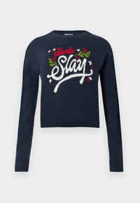 Marinblå kortärmad tröja med långa ärmar. Har broderad text i vitt, rött och grönt "Santa Slay" med höstöverslag. Mjuk stickad textur.