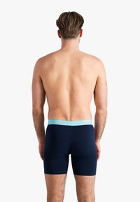 Marineblauwe boxer shorts met een elastische tailleband en lichtblauwe tekst "HAPPY SHORTS". Glad materiaal, aansluitende pasvorm, middeldij lengte.