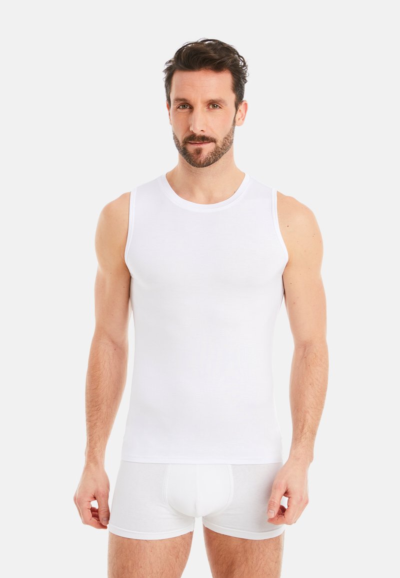 White sleeveless tank top made of cotton fabric. Smooth texture, fitted design, and crew neckline. Worn with matching white boxers.