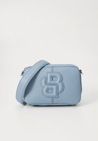 Ανοιχτό μπλε δερμάτινο τσαντάκι χιαστί με υφή, που διαθέτει έντονο ανάγλυφο λογότυπο. Συμπαγές ορθογώνιο σχήμα με μακρύ λουρί.