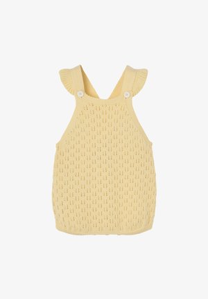 Combinaison bébé en tricot jaune doux avec bretelles, boutons blancs et motif ajouré délicat, présentée sur fond blanc.