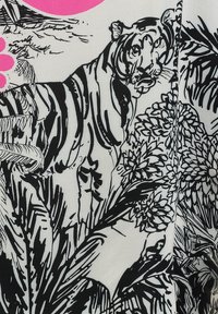 Textil en blanco y negro que presenta un tigre detallado en medio de patrones florales abstractos, con un acento circular rosa en el fondo.