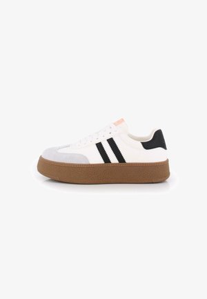 Zapatilla blanca con rayas negras, puntera de gamuza gris y suela de goma marrón texturizada. Acento en rosa claro en la lengüeta.