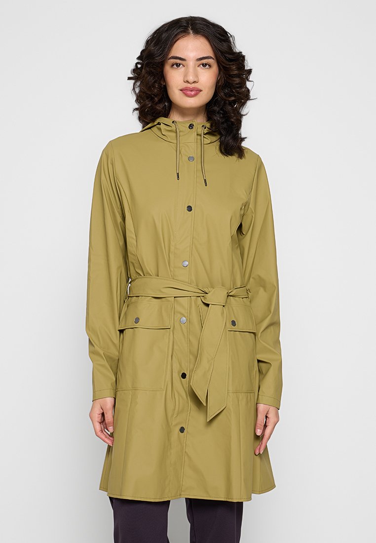 Imperméable vert olive clair fabriqué en matériau résistant à l'eau. Il dispose d'une capuche, d'une ceinture à nouer, de boutons-pression et de deux poches avant.