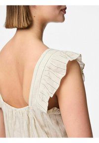 Top senza maniche a righe di colore chiaro, con spalline a volant e una vestibilità morbida, realizzato in un tessuto morbido e texturizzato.