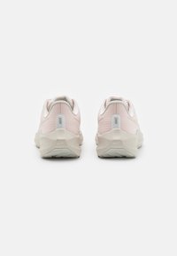 Helle rosa Sportschuhe mit einem strukturierten Obermaterial, weißen Akzenten und einer klobigen beigen Sohle. Verfügt über einen Logotab an der Ferse.