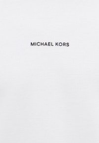 Fehér pamut póló, melyen a "MICHAEL KORS" felirat fekete színben, középen található a mellkasnál. Egyszerű dizájn, puha tapintással.