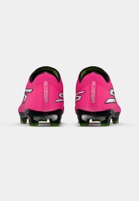 Tacos de fútbol de color rosa brillante con suelas negras, logotipos reflectantes en forma de "S" y la palabra "RAZOR" en las pestañas del talón, mostrados desde atrás sobre un fondo blanco.