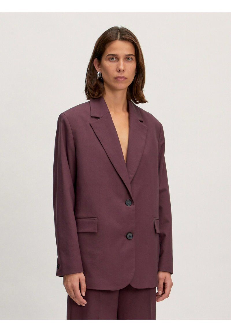 Burgunderfarbener, maßgeschneiderter Blazer mit ausschweifendem Revers, zwei vorderen Taschen und zwei schwarzen Knöpfen, gefertigt aus einem glatten, strukturierten Stoff.