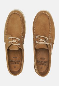 Braune Lederschuhe im Bootsstil mit weißen Nähten und Schnürsenkeln. Sie haben perforierte Innensohlen und eine flache Gummisohle für Traktion und Komfort.