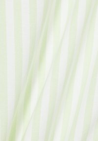 Tessuto bianco con morbide strisce verticali verdi, che mostra pieghe delicate e dettagli della trama.