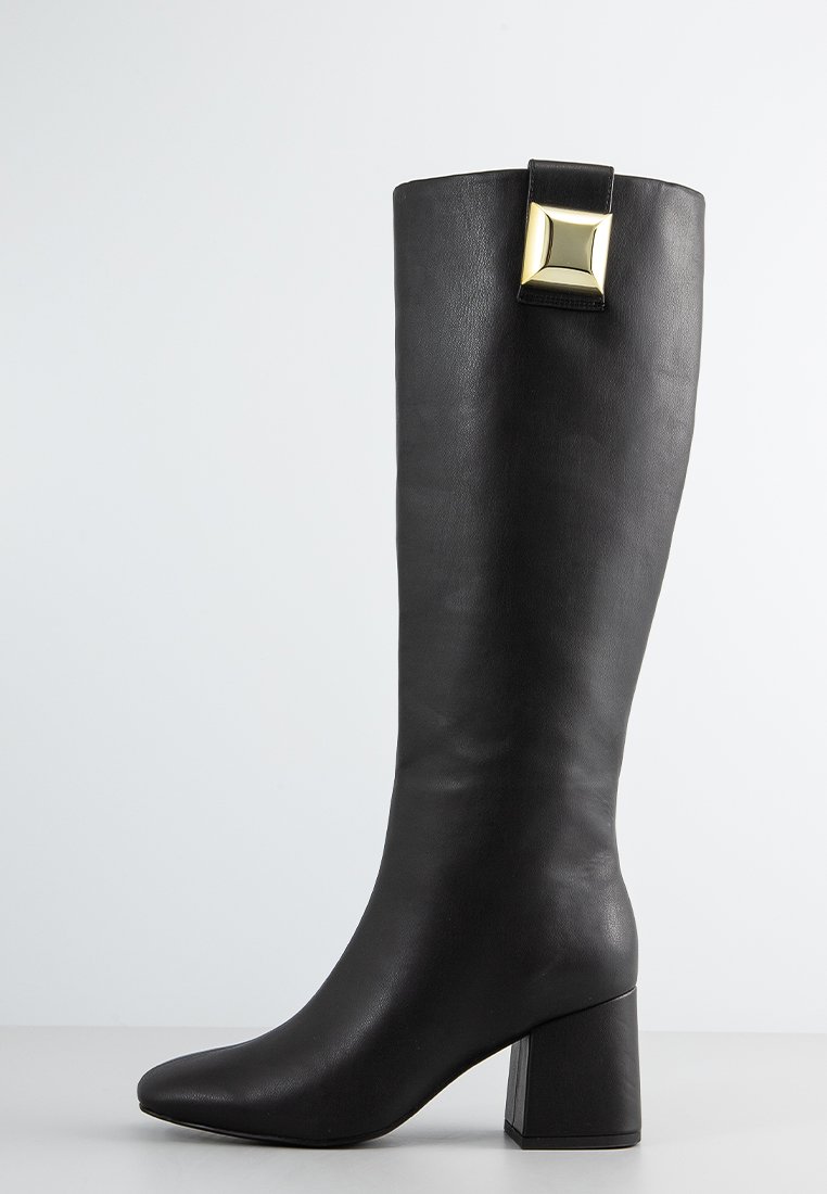 Knöchelhoher schwarzer Lederstiefel mit einem quadratischen Absatz und einem goldenen Akzent am Schaft. Die glatte Textur und das enganliegende Design betonen die Silhouette.