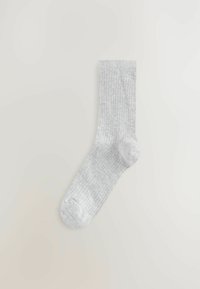 Ljusgrå ribbad strumpa med en slät textur och rund tå, utformad för komfort och vardagsbruk.