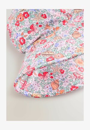 Cvetna blazina z pastelno vijoličasto tkanino in vzorci rdečih, roza in zelenih cvetov, metuljev ter školjk. Mehek, ukrivljen oblik.