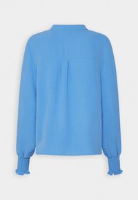 Camicia a maniche lunghe blu con colletto, caratterizzata da dettagli plissettati e polsini arricciati, texture morbida e forma rilassata. Solo vista posteriore.