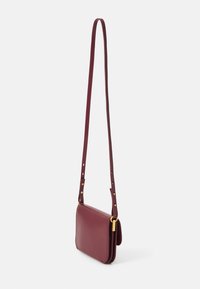 Borsa a spalla in pelle bordeaux con tracolla regolabile, forma rettangolare, superficie liscia e dettagli in metallo color oro.