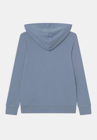 Mikina s kapucí v měkké modré látce. Obsahuje dlouhé rukávy, žebrované manžety a klokaní kapsu. Hladký povrch a ležérní design.