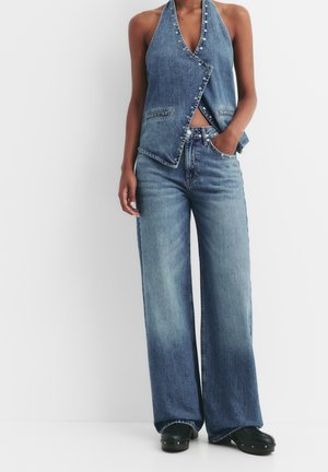 Haut en jean à col halter, bleu clair, avec des accents de boutons ; associé à un pantalon en jean large bleu clair, doté d'une taille haute et de poches avant.