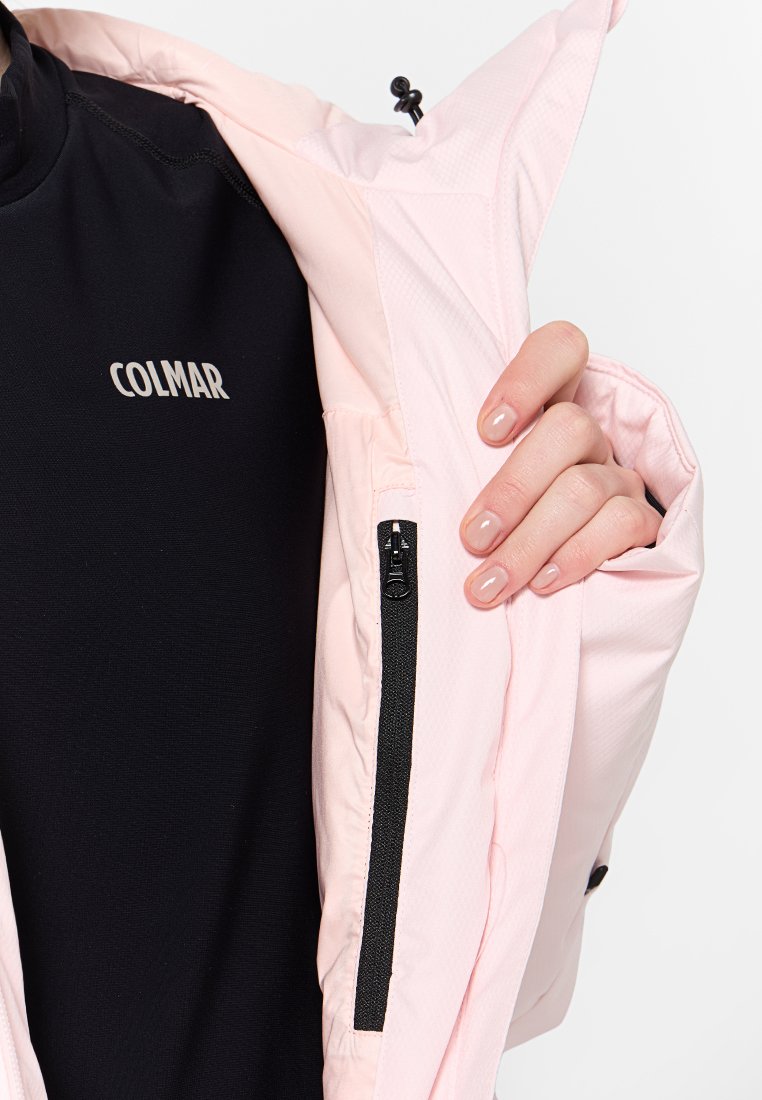 Giacca rosa chiaro con tasca con zip e uno strato interno nero, presenta un logo nella zona del petto e elementi regolabili.