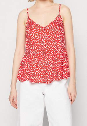 Top senza maniche rosso con pois bianchi, scollo a v, chiusura con bottoni e orlo a peplum. Tessuto leggero con una consistenza morbida.