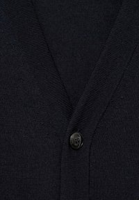 Zbliżenie na czarny sweter z dzianiny z dekoltem w kształcie litery V i jednym czarnym guzikiem zapiętym na środku przodu.