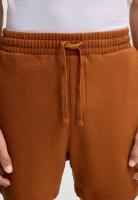 Katoenen shorts in rustkleur, met een textuurstof, elastische tailleband met trekkoord en zijzakken.