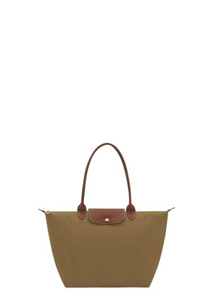 Brown tote bag with long handles, a zippered top, and a small flap with a button closure on the front center.