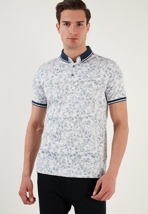 Kurzarm-Polo aus leichtem Stoff, mit weißem Hintergrund und blauem Blumenmuster, marineblauem Kragen und gestreiften Akzenten an den Ärmeln.