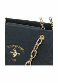 Černá texturovaná kabelka se zlatými detaily, která má řetízkový popruh a embosované logo. Kompaktní design s pevným tvarem.