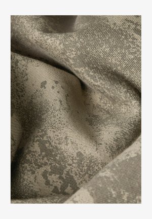 Close-up van beige textiel met een subtiel, iets donkerder onregelmatig patroon en een zacht, gebreid dessin.