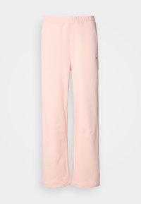Pantalon de jogging en coton rose avec une coupe large, taille élastique et détails de couture minimaux. Comprend une petite étiquette logo sur le côté.
