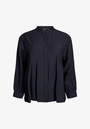Blouse bleu marine à boutonnières avec col mandarin, devant plissé et manches longues bouffantes. Fabriquée en tissu léger et texturé.