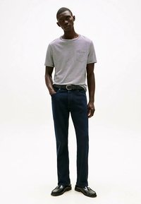 Hallide ja valgete triipudega T-särk ümmarguse kaelusega, tumelõuend sinised teksad, must vöö ja läikivad mustad kingad. Lihtne, keha järgiv disain.