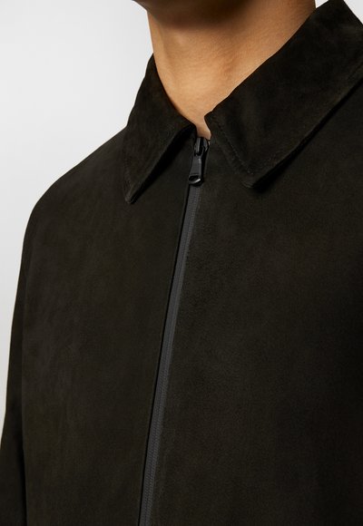 Zwarte suède jas met een kraag en een rits aan de voorkant. Beschikt over een soepele textuur en minimale stiksels.