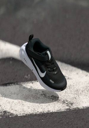 Pantof sporty negru cu un upper texturat și talpă albă. Are un logo swoosh proeminent și o curea pentru o fixare sigură.