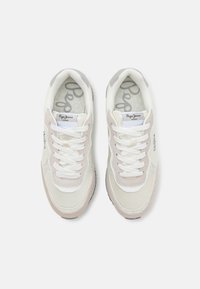 White and light gray sneakers with a suede and mesh upper, round toe, white laces, and patterned insole. Features logo on side. Rubber sole.