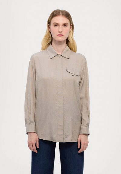 Light beige long-sleeve button-up shirt with a collared neck, vertical stripes, and a small chest pocket. Smooth, slightly textured fabric.