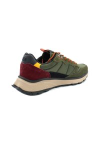 Sneaker verde in materiali misti con accenti marroni e neri. Presenta una parte superiore testurizzata, lacci arancioni e una suola spessa beige con un battistrada decorato.