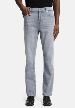 Light gray jeans in faded denim with a straight leg cut, five-pocket design, and metal button closure. Worn with black shoes.