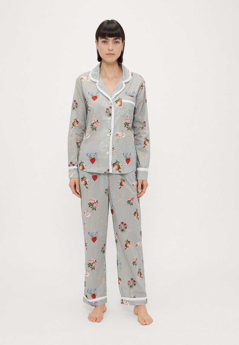 Conjunto de pijama de algodão com um padrão riscado, apresentando motivos florais e de corações. Inclui uma blusa de botão e calças de elástico, ambas com punhos.